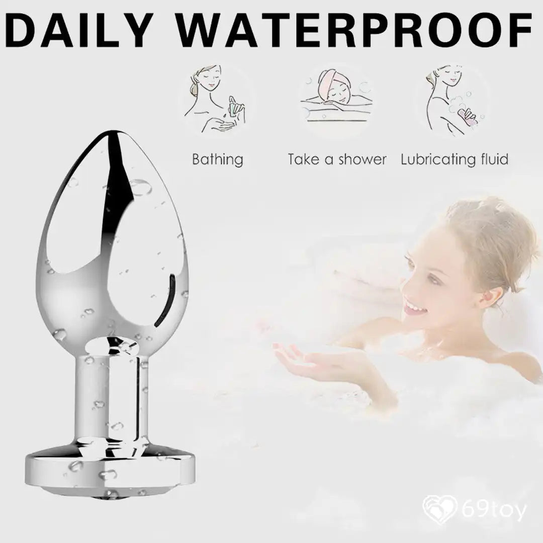 Chrome-colored butt plug with icons and text indicating water resistance, bathing, showering, and lubricating fluid.