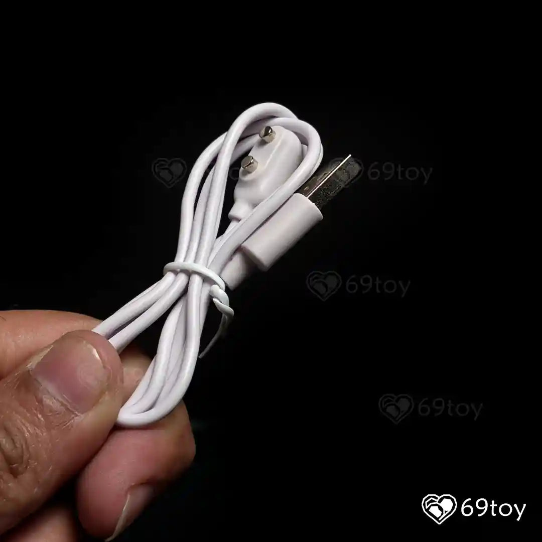 White USB cable held by a hand against a black background .