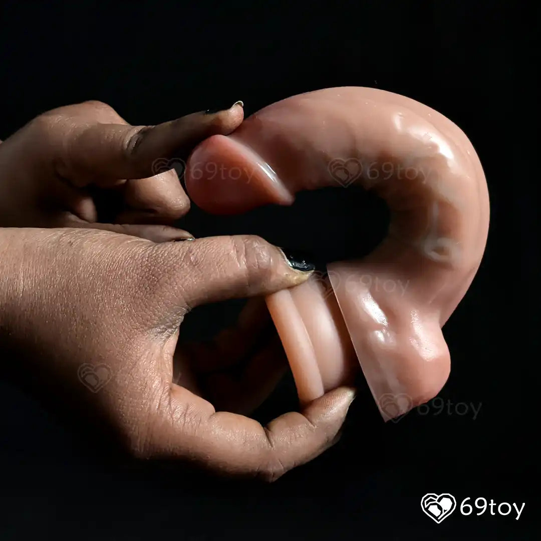 Hand holding a silicone dildo  with a dark background